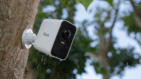 Roku Battery Camera mounted to a tree with rain falling on it