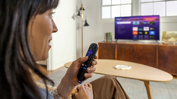 Persona utilizando el Roku&nbsp;Voice&nbsp;Remote con el Roku&nbsp;Streaming&nbsp;Stick&nbsp;Plus para controlar la TV