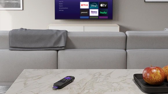 Roku Voice Remote controlling a TV in a living room setting