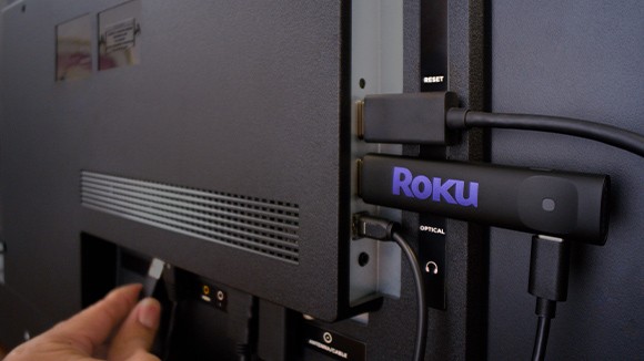 The Roku Streaming Stick Plus plugged into a port in the back of a TV