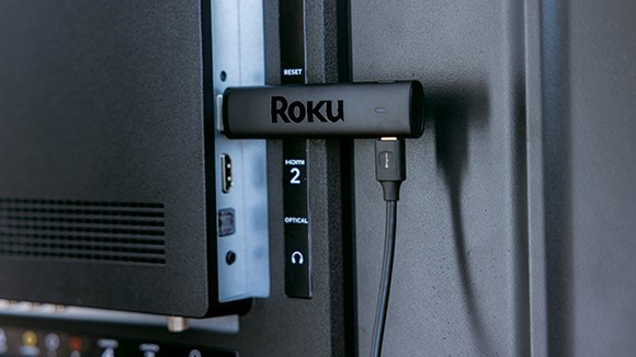 The Roku Streaming Stick 4K plugged into a port in the back of a TV