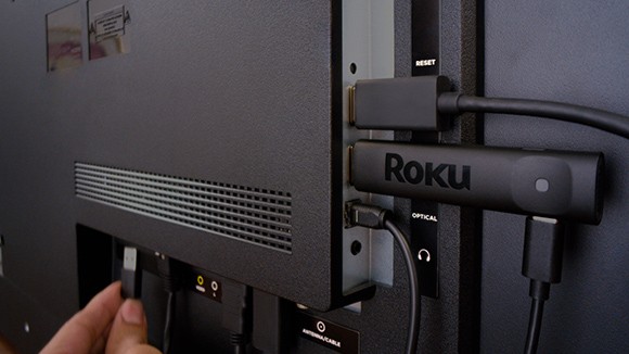 El Roku Streaming Stick Plus conectado a un puerto en la parte posterior de una TV
