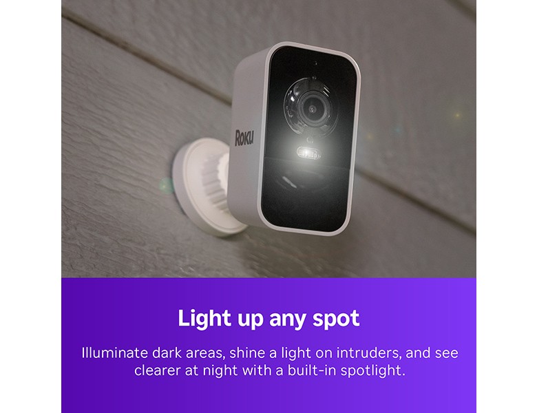 Roku Battery Camera mounted to the side of a house with the spotlight turned on