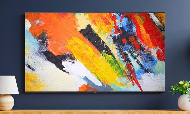 Front view of the Roku Pro Series 4K Mini-LED TV mounted on a wall with Backdrops gallery art